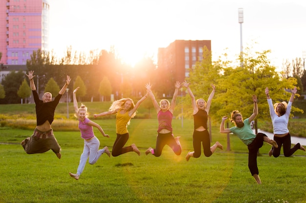 Eine Gruppe von Menschen springt gegen den Sonnenuntergang