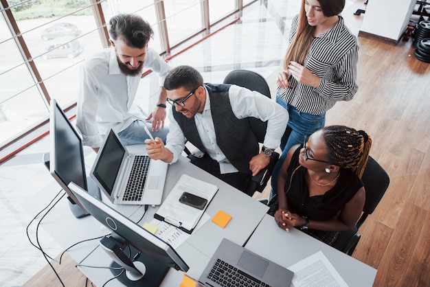 Eine Gruppe von multinationalen Beschäftigten, die im Büro arbeiten. Höhenansicht