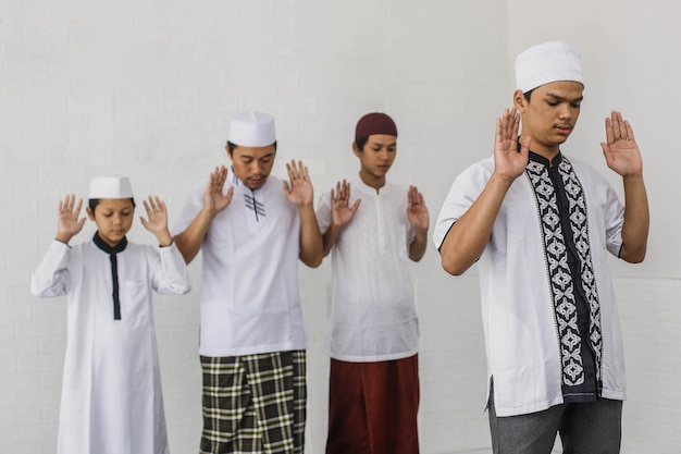 Eine Gruppe von Muslimen betet gemeinsam mit Takbir-Posen in der Moschee