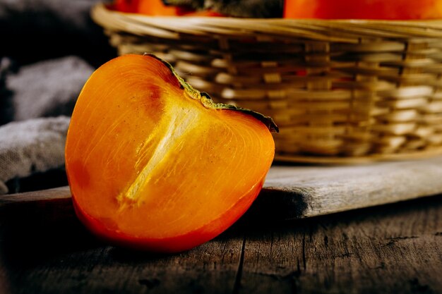 Eine Gruppe von reifen orangen PersimmonfrüchtenPersimmonfrüchte auf einem rustikalen Hintergrund aus Holzbrett