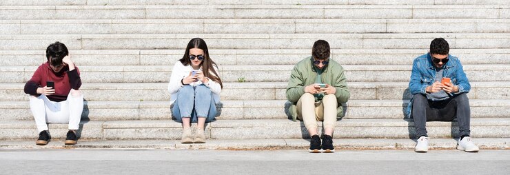 Eine Gruppe von Teenagern konzentrierte sich auf Telefone und hielt Abstand