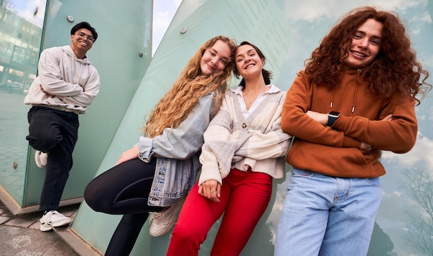 Eine Gruppe von vier verschiedenen Teenager, die nach der Schule zusammen sind und fröhlich in die Kamera schauen