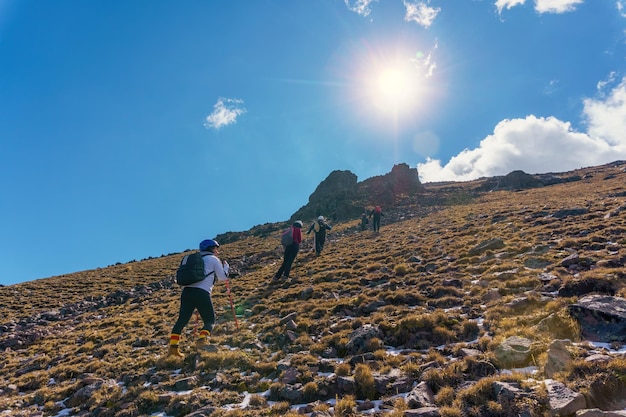 Eine Gruppe von Wanderern, die schwere Rucksäcke auf einem Bergpfad tragen
