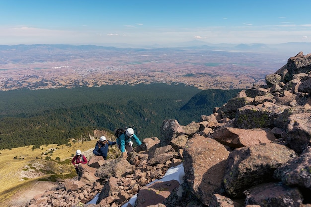 Eine Gruppe von Wanderern, die schwere Rucksäcke auf einem Bergpfad tragen