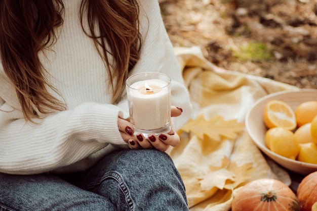 Eine gute Zeit im Freien im Herbstwald haben und aromatische Kerzen verbrennen