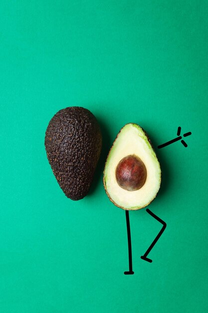 Eine halbe Avocado mit gezeichneten Armen und Beinen