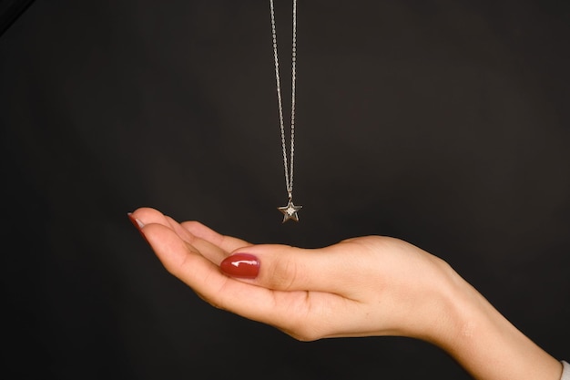 eine Halskette mit einem silbernen Stern hängt an einer Kette