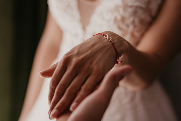 Foto eine hand des hochzeitspaares berührt sich. hände jungvermählten mit eheringen schließen