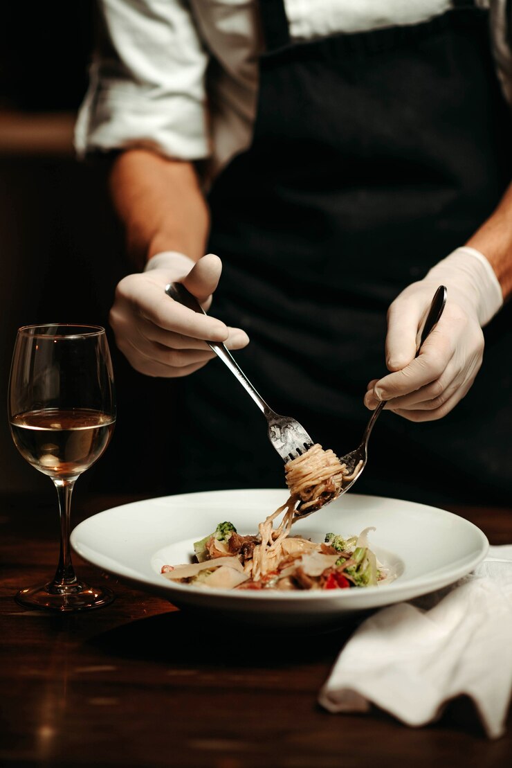 Foto eine hand des küchenchefs, die nudeln auf einer gabel wickelt
