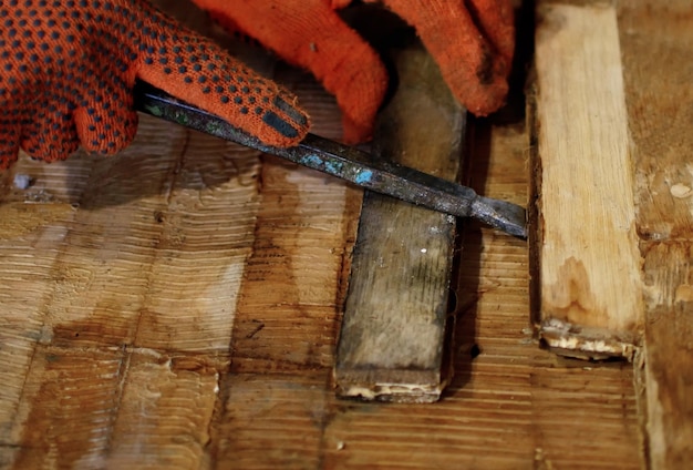 Foto eine hand, die ein stück holz mit einem messer darauf hält