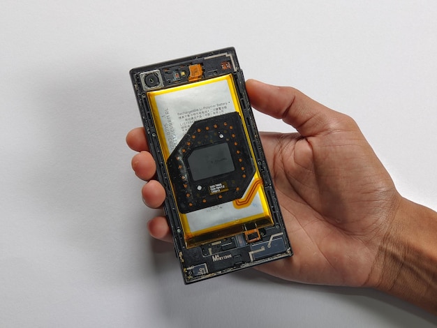 Eine Hand, die ein Teardown-Telefon auf isoliertem Hintergrund hält