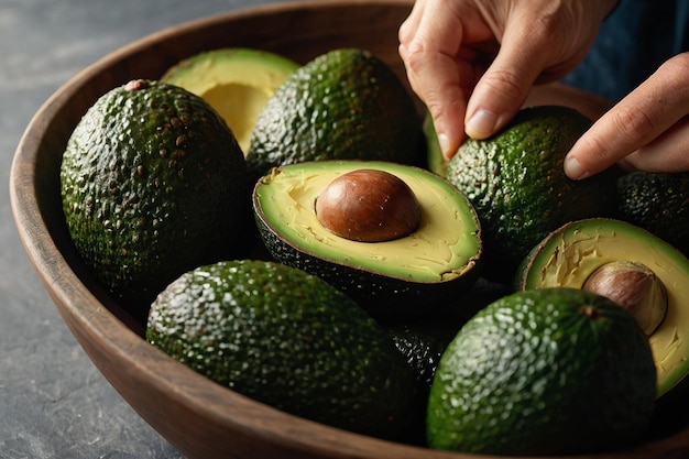 Eine Hand, die reife Avocados in einer Schüssel zerkleinert