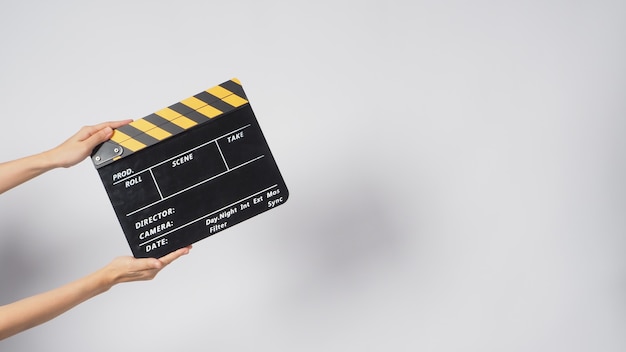Eine Hand hält Black & Yellow clapperboard oder Filmschiefer auf weißem Hintergrund. Es hat eine Zahl geschrieben.