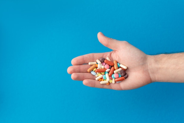 Eine Handvoll farbiger Pillen auf der Handfläche. Medizinisches Konzept. Einkaufen in der Apotheke.