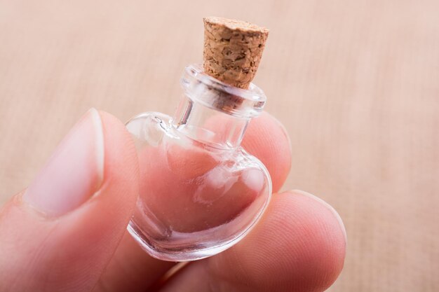 Eine herzförmige Glasflasche wird in der Hand gehalten