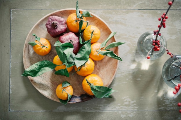 Eine Holzschale mit Orangen-Zitrusfrüchten auf einer Tischplatte