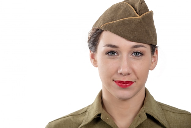 Eine hübsche junge Frau in wwii Uniform uns mit Garnisonsmütze auf weiß