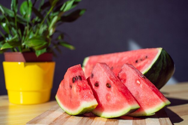 Eine in Scheiben geschnittene reife Wassermelone liegt auf einem Holztisch