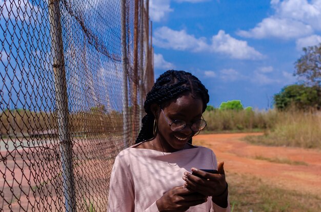 Eine junge afrikanische Dame, die ihr Handy bedient