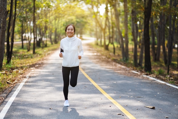 Eine junge Asiatin, die morgens im Stadtpark joggt