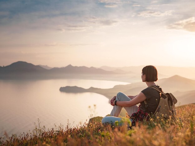 Eine junge asiatische Frau mit einem Rucksack, der im Sommer wandert