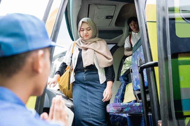 Eine junge asiatische Touristin mit Rucksack, die aus dem Reisebus geht?