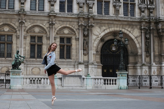 Eine junge ballerina tanzt auf der straße von paris