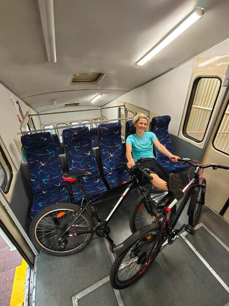 Eine junge blonde Frau fährt mit zwei Fahrrädern im Stadtverkehr Tourismus, Sport und aktive Erholung