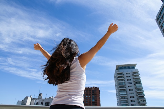 Eine junge erwachsene Frau, die Yoga in einer städtischen Umgebung praktiziert.