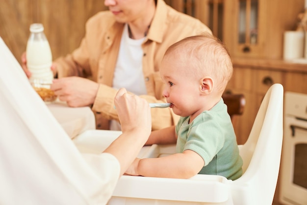 Eine junge Familie füttert ein Kind beim Frühstück