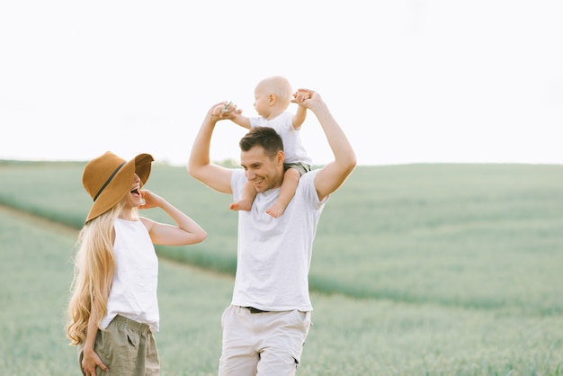 Eine junge Familie hat Spaß mit ihrem kleinen Baby auf dem Feld