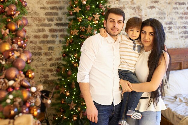 Eine junge Familie in der weihnachtlich geschmückten Wohnung