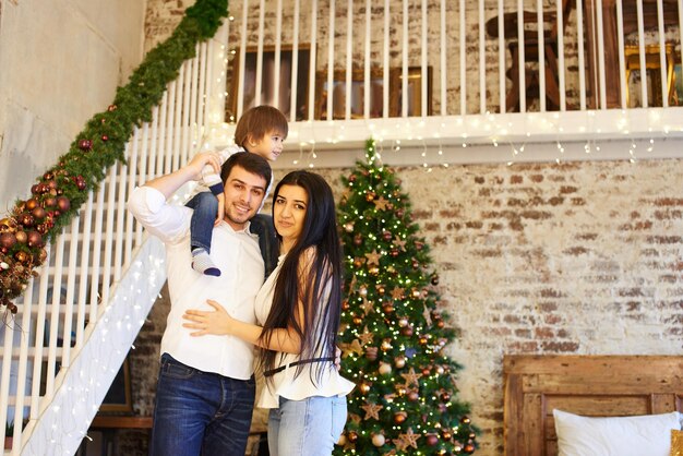 Eine junge Familie in der weihnachtlich geschmückten Wohnung