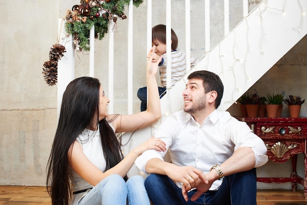 Eine junge Familie in der weihnachtlich geschmückten Wohnung