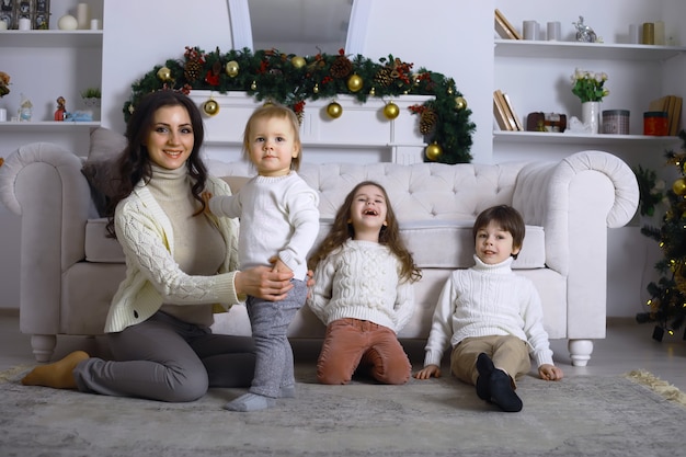 Eine junge Familie mit Kindern schmückt das Haus für den Urlaub. Silvester. Warten auf das neue Jahr.