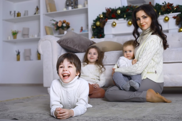 Eine junge Familie mit Kindern schmückt das Haus für den Urlaub. Silvester. Warten auf das neue Jahr.