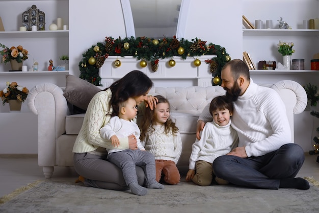 Eine junge Familie mit Kindern schmückt das Haus für den Urlaub. Silvester. Warten auf das neue Jahr.