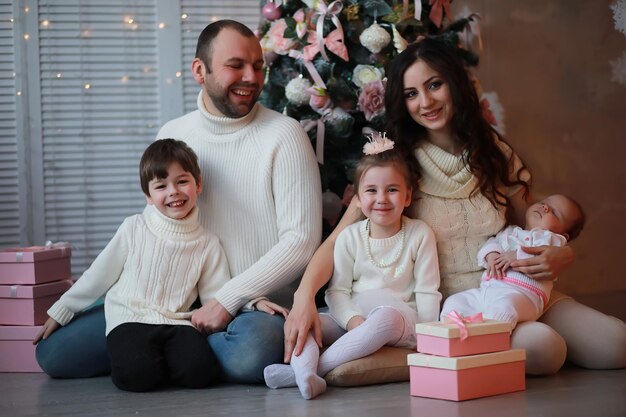 Eine junge Familie mit Kindern schmückt das Haus für den Urlaub. Silvester. Warten auf das neue Jahr.