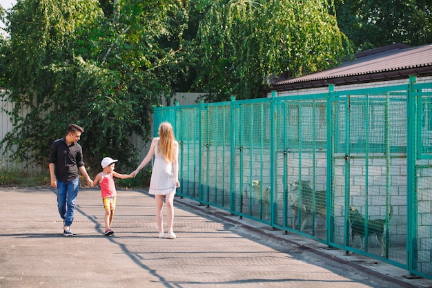 Eine junge Familie sucht ein Haustier in einem Hundehaus.