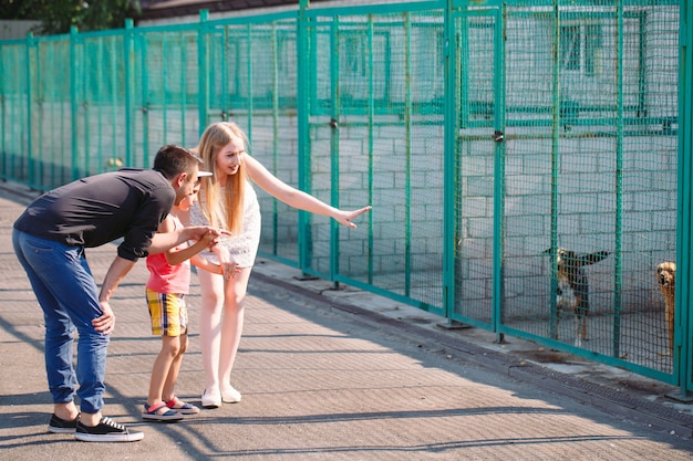 Eine junge Familie sucht ein Haustier in einem Hundehaus.