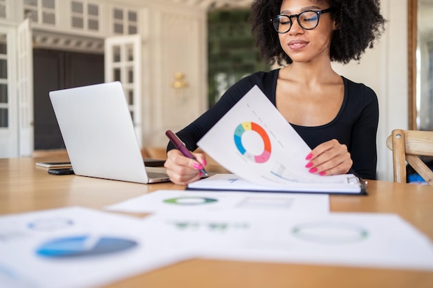 Eine junge Frau arbeitet tagsüber im Büro eines lockigen Finanziers mit Brille