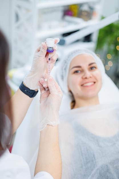 Eine junge Frau bei einem Termin mit einer Kosmetikerin Beauty-Injektionen für das Gesicht Behandlungsablauf bei einem Dermatologen