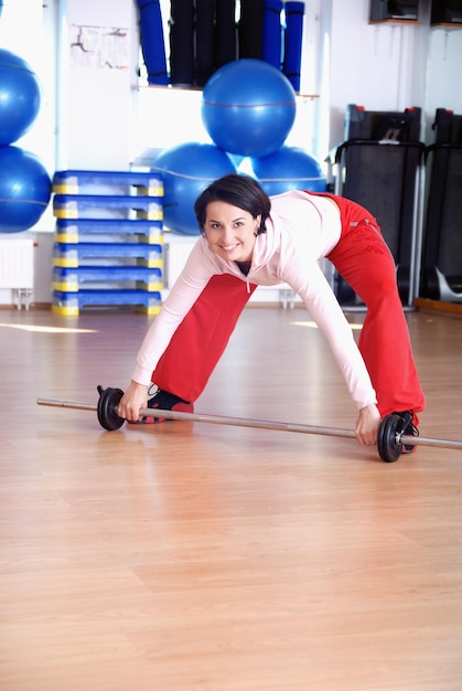 .eine junge Frau beim Gewichtheben im Fitnessstudio