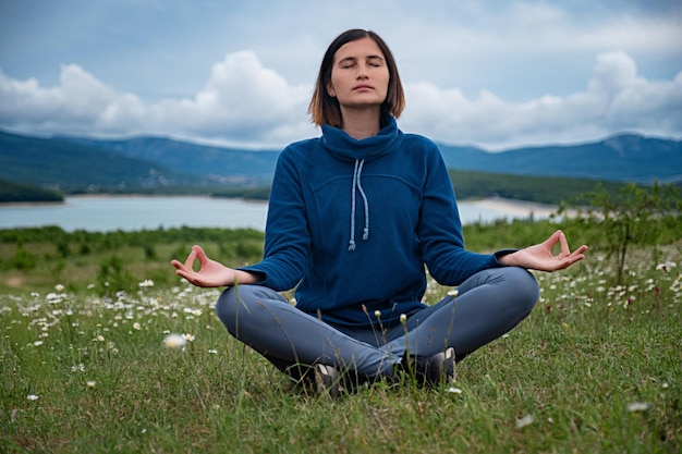 Eine junge Frau beim Yoga auf dem Feld