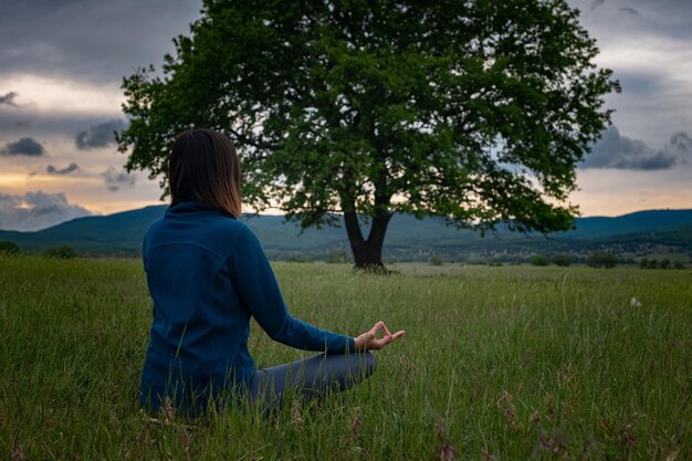 Eine junge Frau beim Yoga auf dem Feld