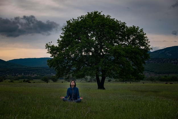 Eine junge Frau beim Yoga auf dem Feld