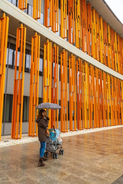 Eine junge Frau besucht die Gebäude in den Farben Rot, Orange und Gelb der Gebäude der Internationalen Ausstellung in der Stadt Zaragoza, Expo 2008, neben dem Ebro in Aragon. Spanien