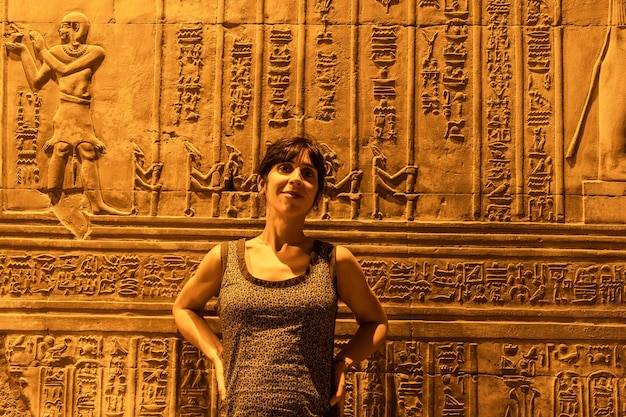 Eine junge Frau betrachtet ägyptische Zeichnungen und Hieroglyphen im Tempel von Kom Ombo