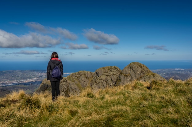 Eine junge Frau, die die Ansichten von Peñas de Aia, Guipuzkoa beobachtet. Baskenland