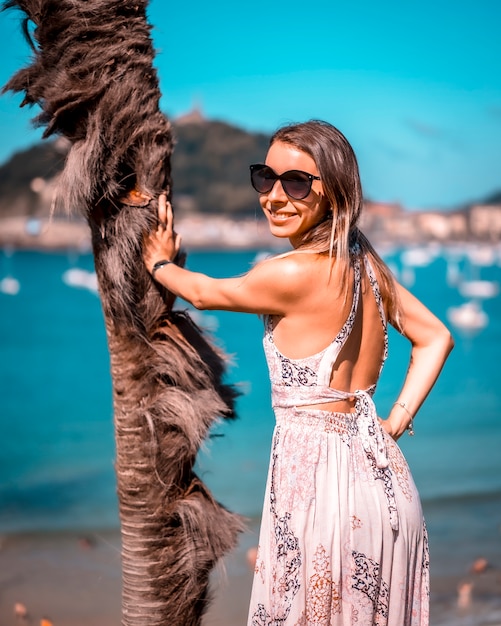 Eine junge Frau, die die Aussicht auf den Strand in San Sebastian genießt. Lifestyle-Sitzung, vertikales Foto